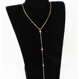 Gold tone rhinestone lariat necklace draped as a Y drop on a black display bust stand
