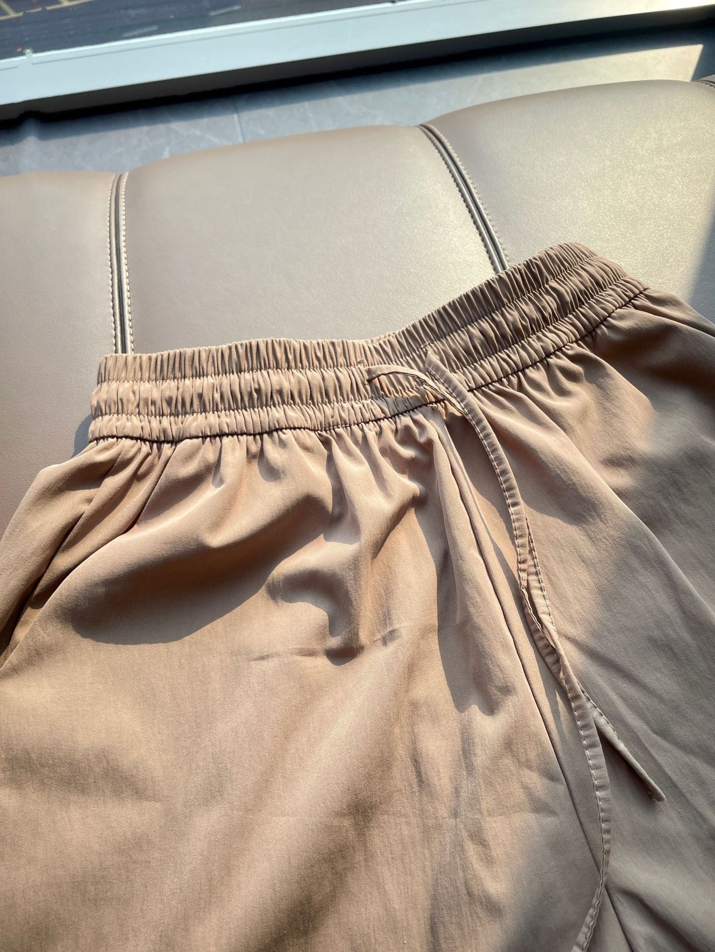 Detail of the ice silk shorts side seam pocket stitched flat against the hip