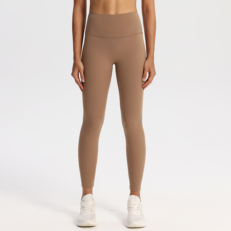 High-waisted stretch yoga leggings for women paired with white sneakers in studio