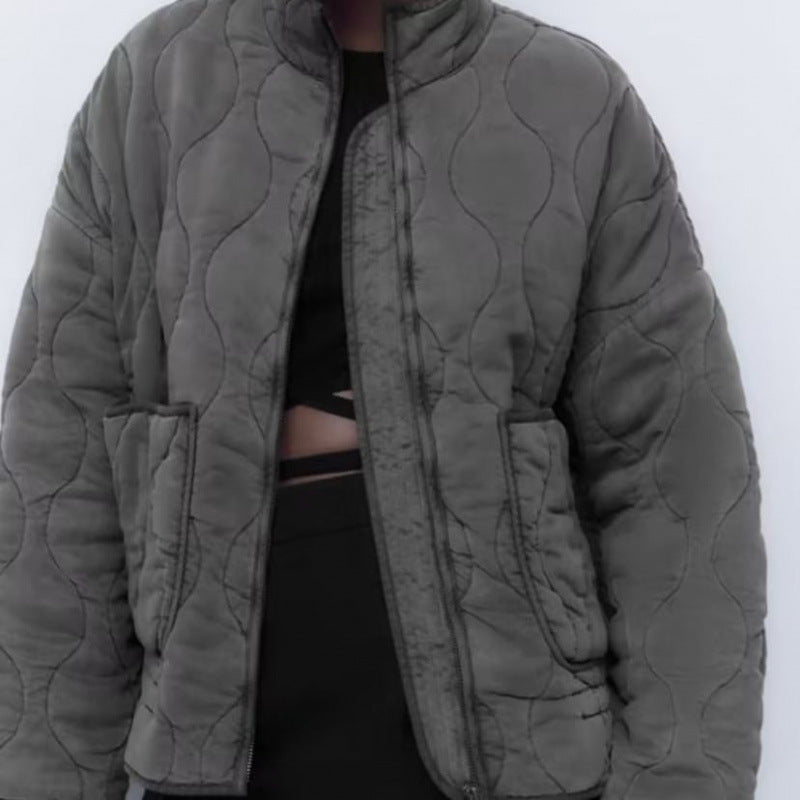 Gray quilted jacket worn open on a model, showing two large front patch pockets and the quilting