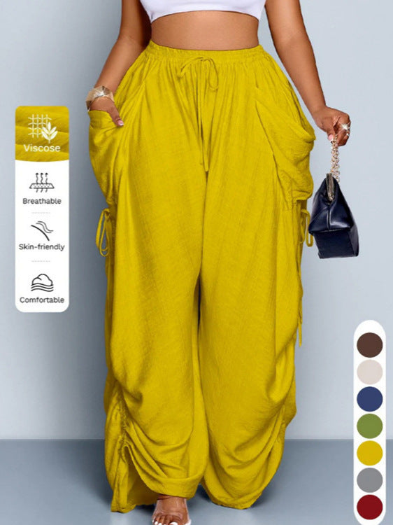 High waist wide leg linen look viscose drawstring trousers, front view on a model with hands in the deep pockets