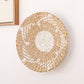 Magenta and natural straw woven wall ornament with a coiled spiral face
