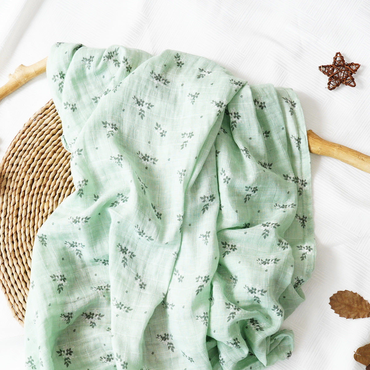 Pure cotton muslin swaddle blanket rolled up, showing the airy gauze texture and printed design