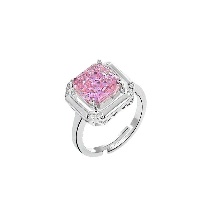 Radiant cut pink simulated diamond held in an open square frame on an adjustable silver toned band, white background