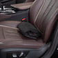 Black terry cloth seat cover folded flat on a brown leather car seat, showing its compact folded size