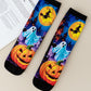 Pair of mid-calf socks printed with a ghost, a witch on a broom across a yellow moon and two pumpkins