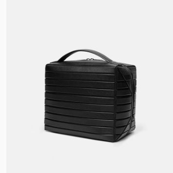 Ribbed stripe makeup organizer bag with a top handle and wrap around zip on a plain background
