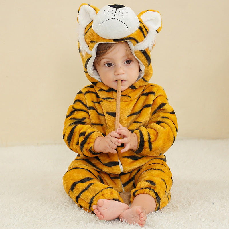 Baby in a striped tiger flannel romper with a tiger face hood, holding a wooden stick on a cream rug