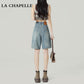 Back view of loose knee-length denim shorts in faded blue non-stretch cotton