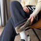 Navy blue ribbed fleece lined wide leg pants with a white drawstring and a plush rolled cuff, seated view