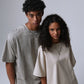 Man in a washed light gray t-shirt beside a woman in a cream washed t-shirt, loose dropped-shoulder fit