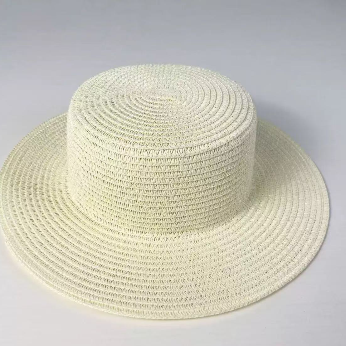 Milky white flat top straw sun hat with a wide even brim on a plain background