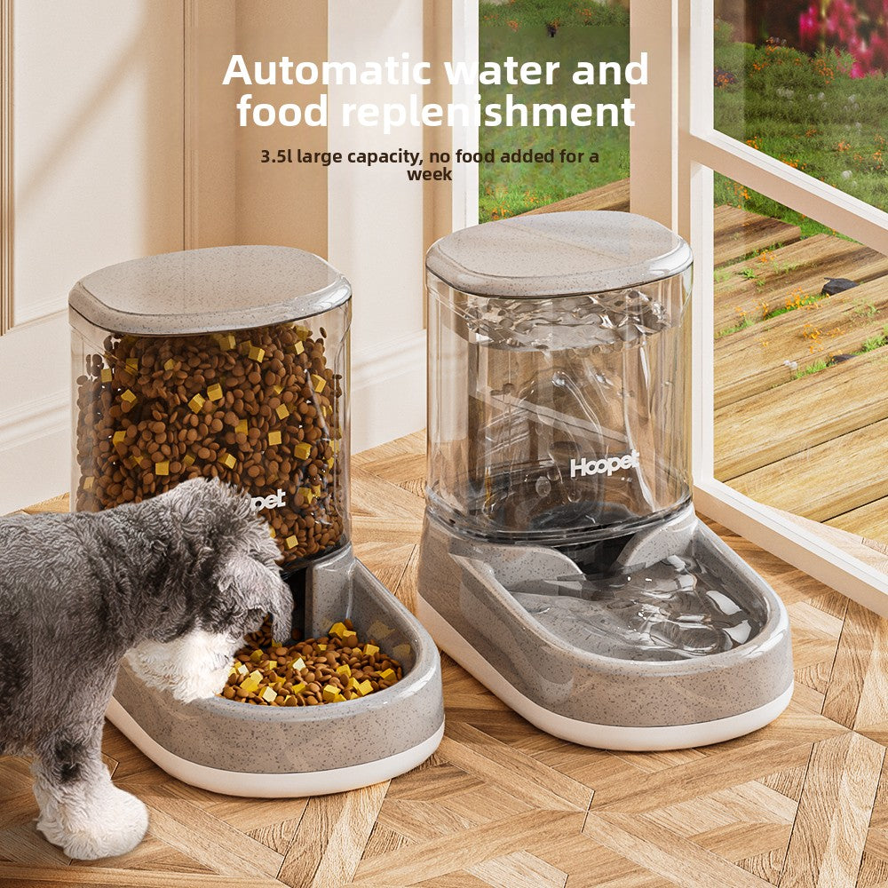 Clear reservoir gravity pet feeder holding dry kibble above a gray bowl