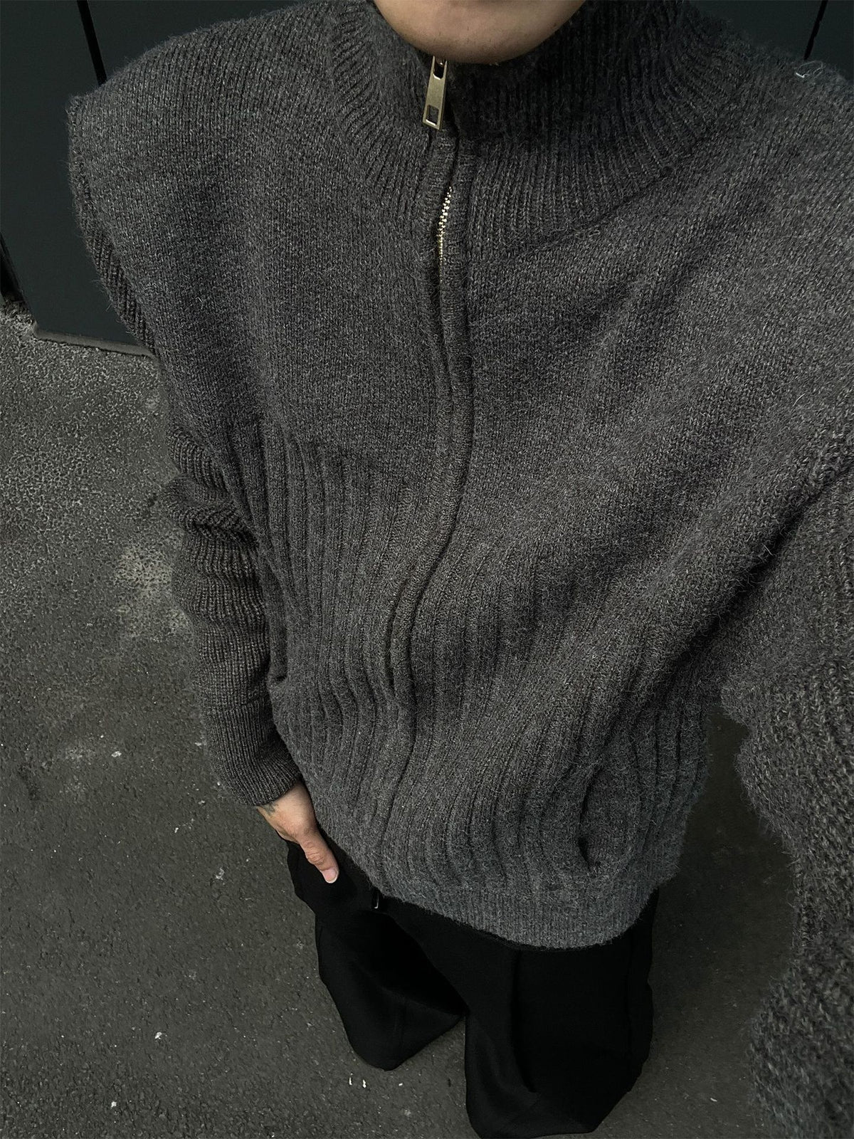 Close-up of the high stand collar, metal zipper pull and ribbed chest panel of the gray knit cardigan