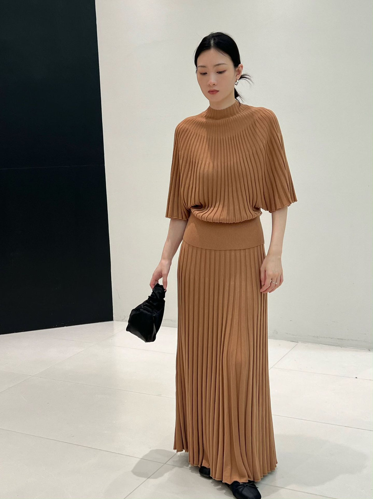 Caramel long ribbed knit skirt styled with a knit top and black bag, front view, top not included