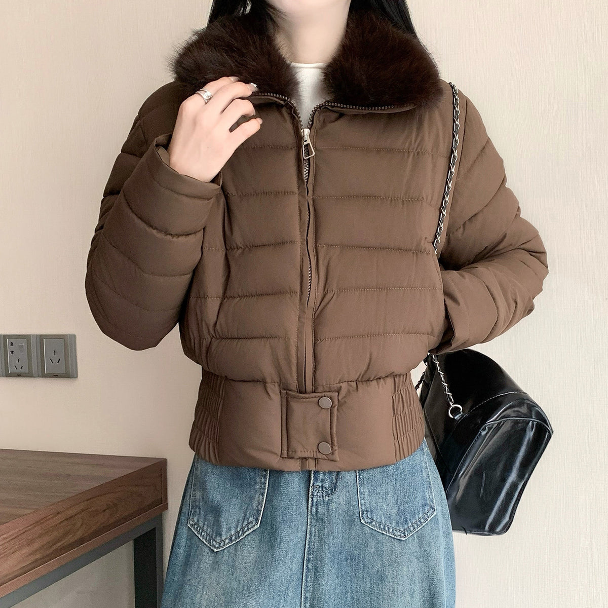 Coffee cropped padded puffer jacket with a faux fur collar worn zipped on a model