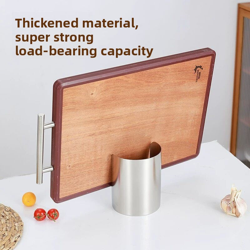 Small stainless steel holder with a wooden cutting board standing on its edge against it on a white counter