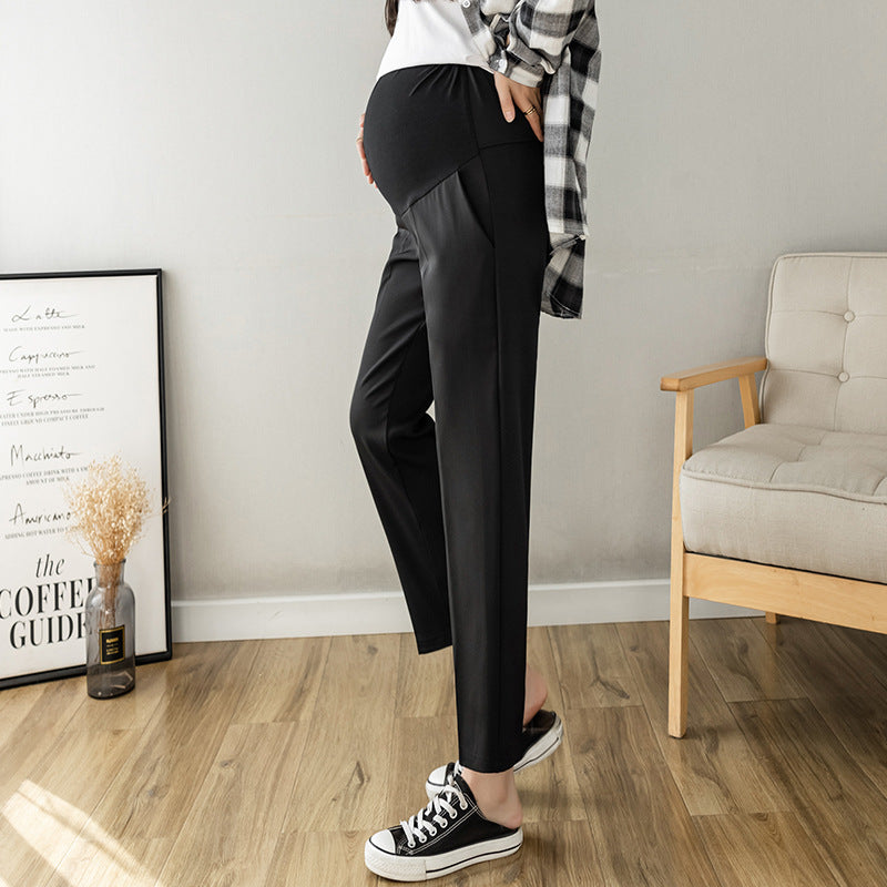 Black maternity cropped trousers worn by a model showing the straight tailored leg