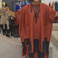 Orange red boubou kaftan dress with beaded placket and fringed color block hem worn with a black head wrap