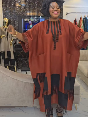Orange red boubou kaftan dress with beaded placket and fringed color block hem worn with a black head wrap