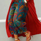 Wide leg cropped denim jeans with teal and orange paisley swirl print, red coat and heels