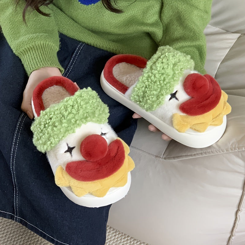 Pair of clown face plush slippers resting on a lap showing the open back, red trim and beige plush lining