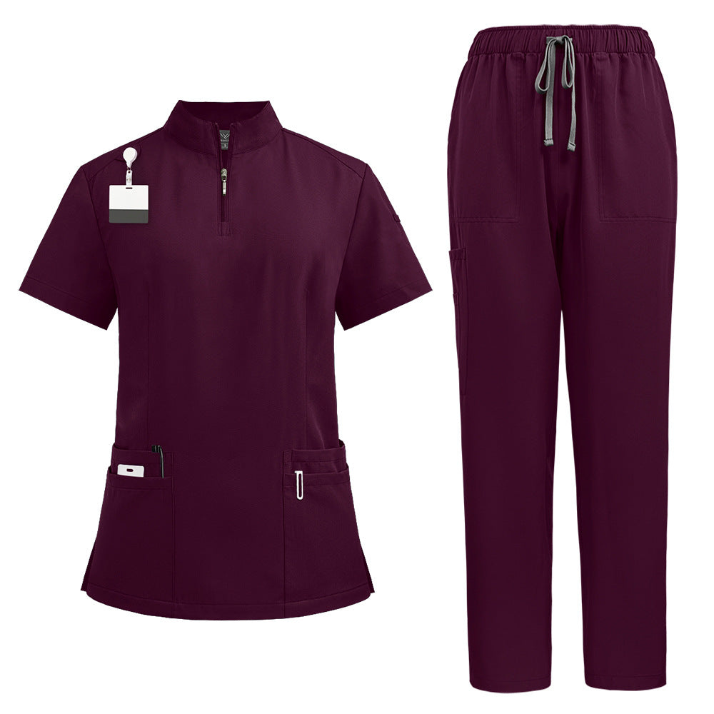 Scrub top worn while the model reaches to show the stretch in the fabric