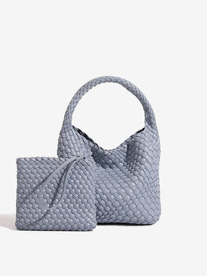 Grey woven PU leather bucket bag with plaited top handle beside its matching woven zip pouch