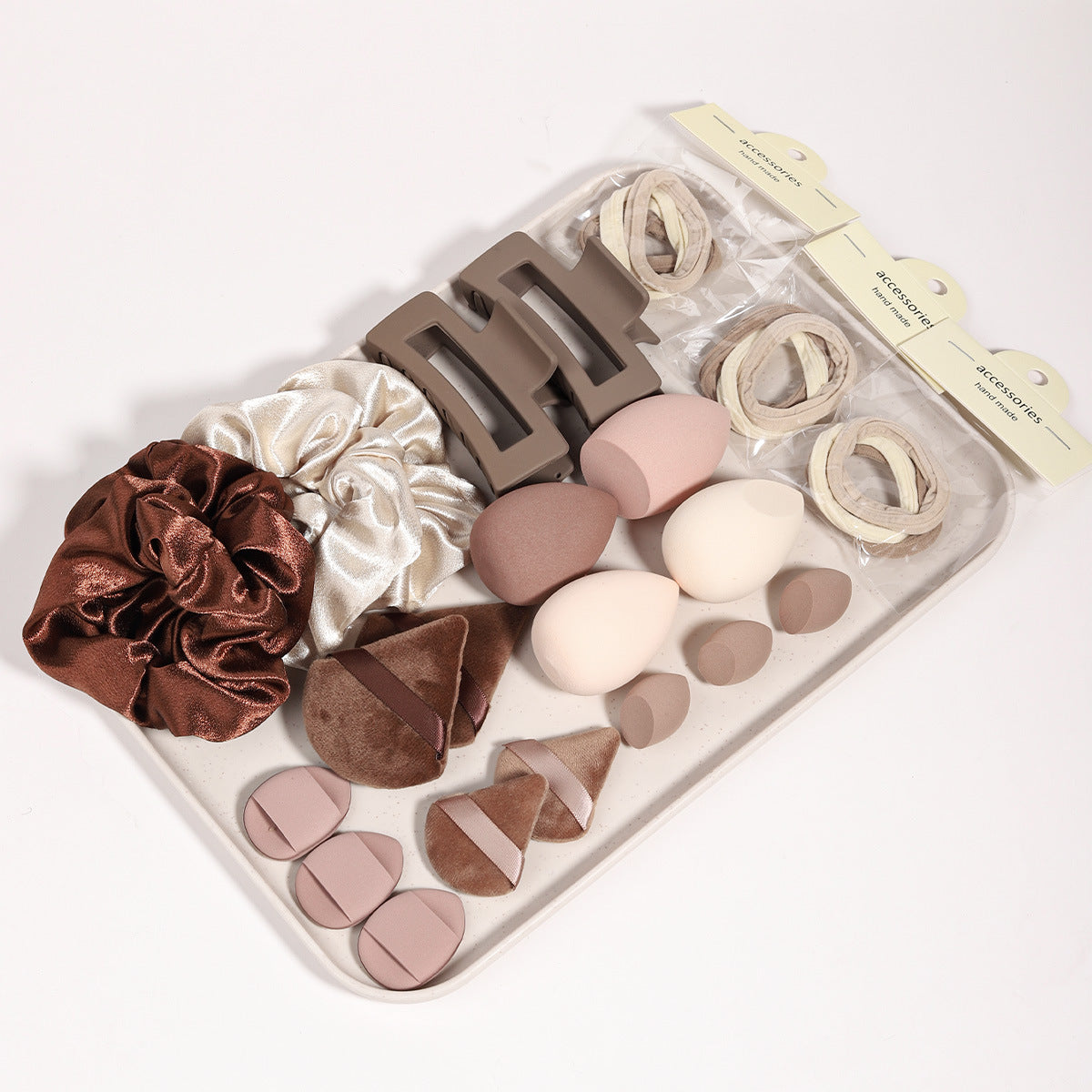 Velvet triangle powder puffs and round puffs beside teardrop foam makeup sponges