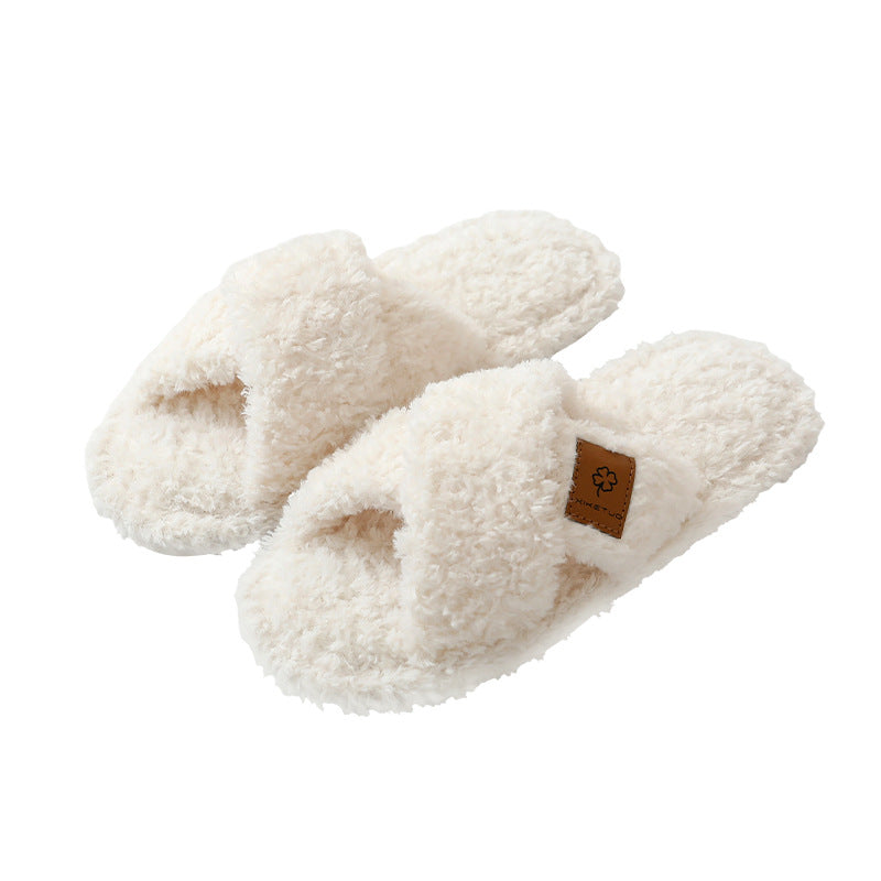Pair of Beige crossed plush open toe slippers on a white background