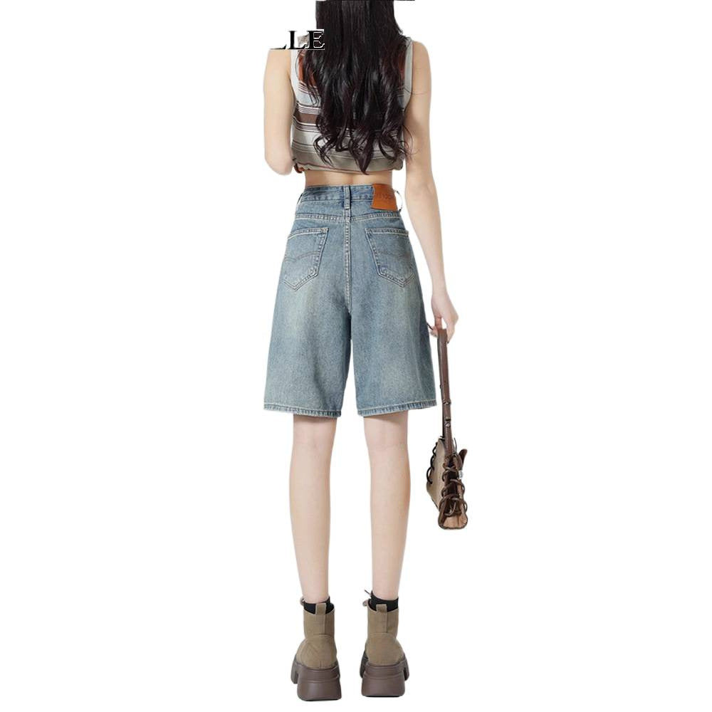 Rear view of wide-leg knee-length denim shorts showing back patch pockets