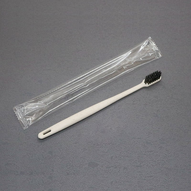 Disposable toothbrush and toothpaste travel set shown with its sealed film pouch on a plain ground