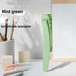 Single mint green silicone bookmark clip standing on a desk beside a pen cup