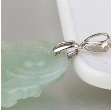 Macro of a pinch-bail finding gripping a pale green stone pendant