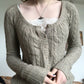 Close up of the khaki cable knit cardigan with a gathered scoop neckline and round tonal buttons