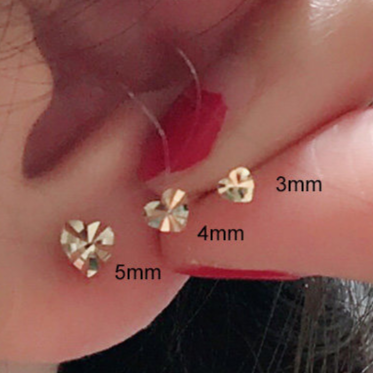 Mini heart gold stud earring shown next to thin hoops for a stacked ear set