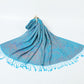 Azure blue paisley jacquard scarf spread on a white background with twisted blue tassel fringe