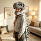 Plush dinosaur skull costume hood with an open toothy jaw and a padded crystal velvet spine tail