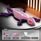 Green robotic lizard toy with articulated legs and tail and a glowing patterned back on a stand