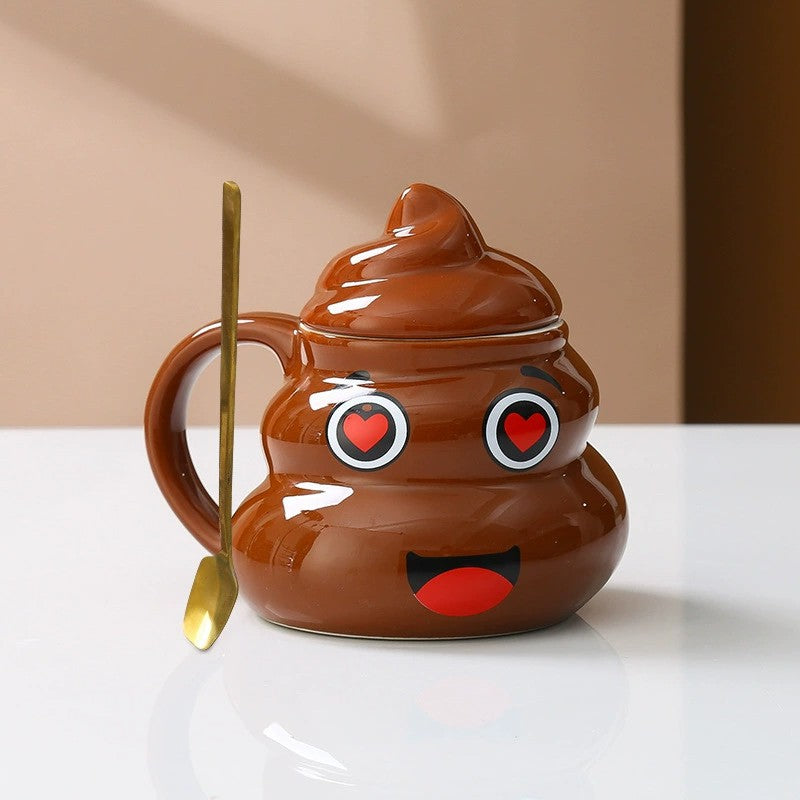 Brown ceramic poop emoji mug beside a small matching spoon and a printed gift bag