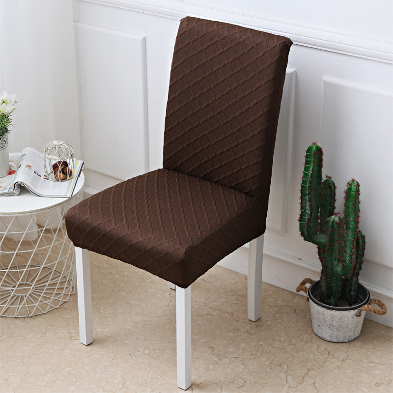 Hand pulling a stretch jacquard cover onto a dining chair seat
