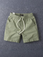 Army green men's cotton drawstring shorts laid flat with the drawstring untied