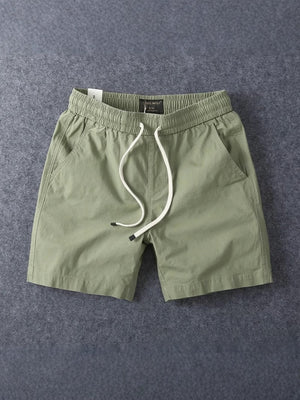 Army green men's cotton drawstring shorts laid flat with the drawstring untied