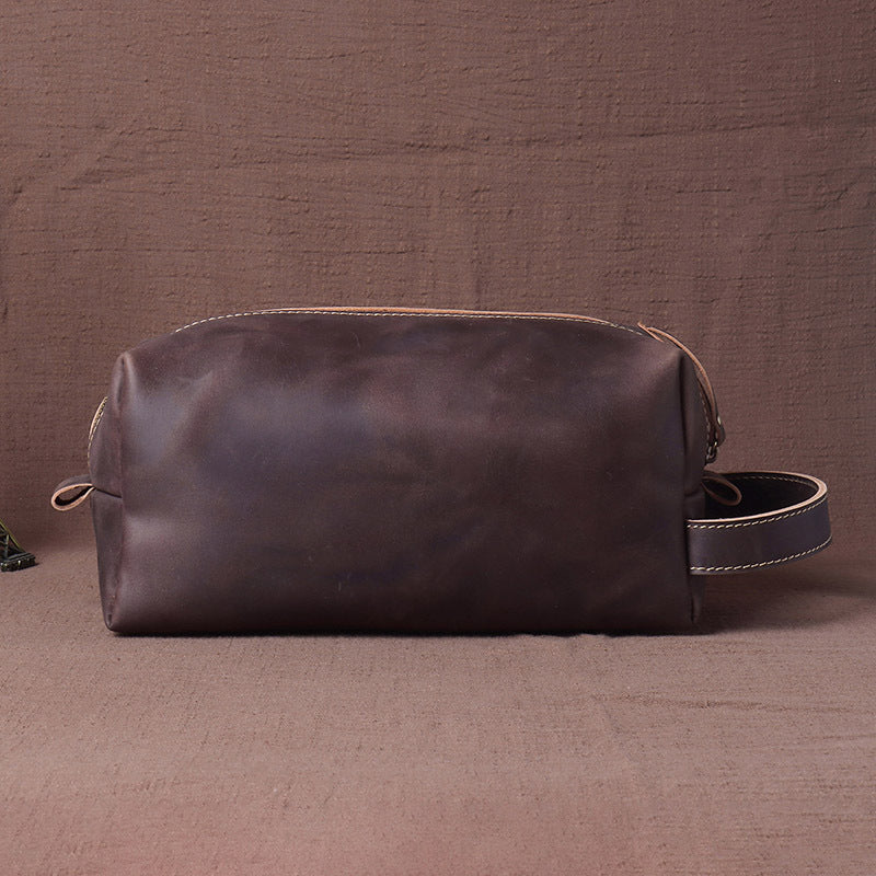 Distressed cowhide leather dopp kit shown on a neutral cloth surface