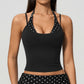 Model in a cropped camisole with a printed halter inset, black with white polka dots