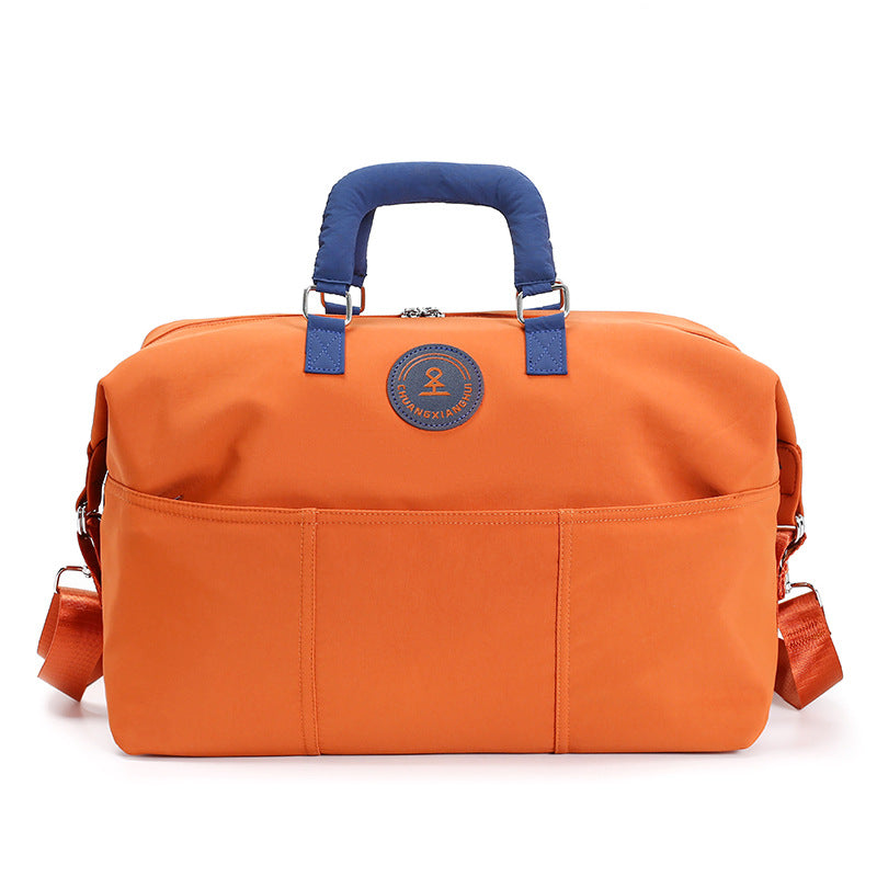 Orange duffel travel bag with navy blue padded handles and front slip pockets, option Orange