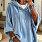 Relaxed womens hooded top with a soft sheen and dropped shoulders indoors