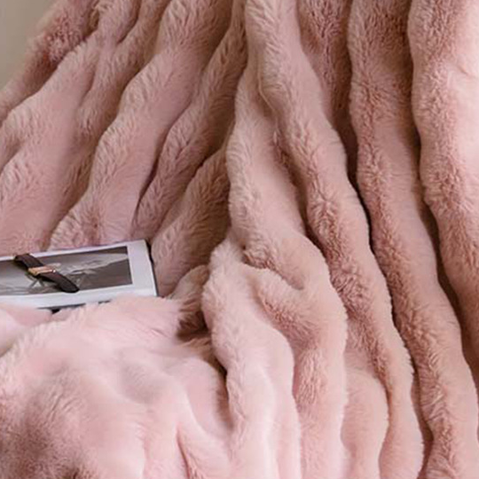 Folded plush ruched throw blanket showing its thickness and soft fleece surface