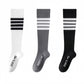 White, grey, and black long compression socks side by side with three-stripe bands