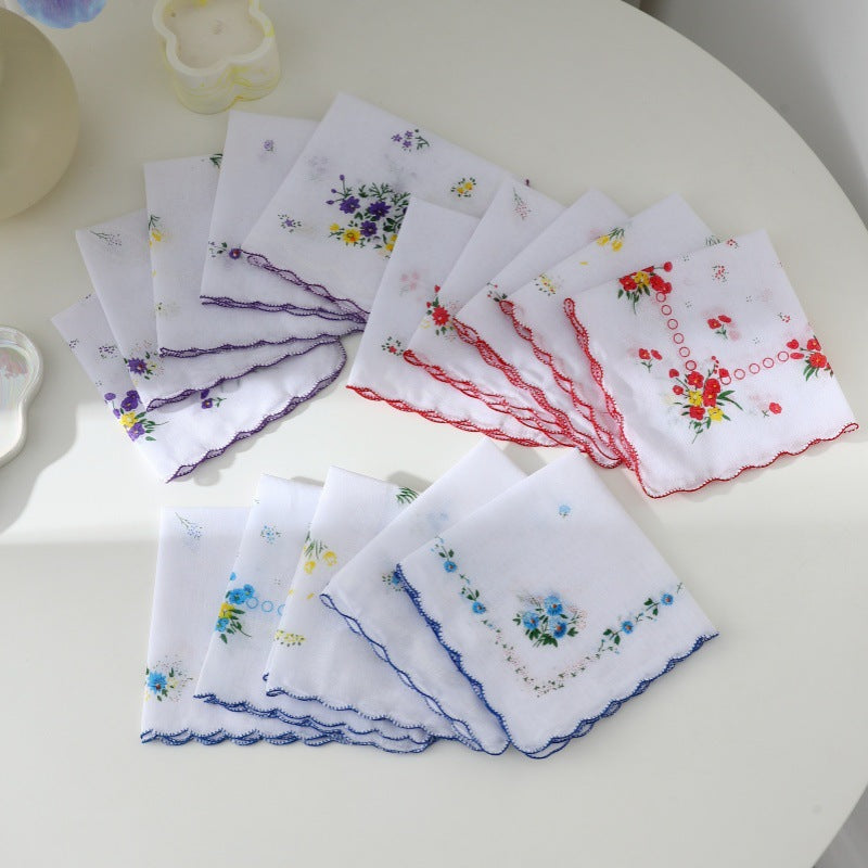 White cotton handkerchiefs printed with vintage floral bouquets and edged in blue red and purple stitching